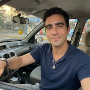 Conductor al volante de un automóvil en una calle urbana, imagen representativa del tránsito diario