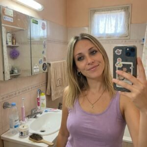 Mujer en el baño de su casa durante su rutina diaria, imagen representativa de la vida cotidiana.