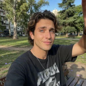 Joven sonriente en un parque que contrató a un abogado migratorio del Estudio Sanchez Ferre para resolver su problema migratorio