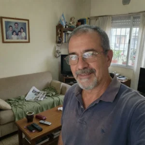 Persona en su living tomando mate en un momento cotidiano de su hogar mientras atraviesa un tema de consorcios.