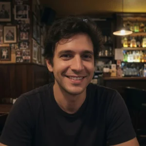 Abogado especialista en derecho administrativo: retrato de un hombre joven sonriendo en un ambiente cálido, representando a alguien que superó un problema administrativo con éxito.