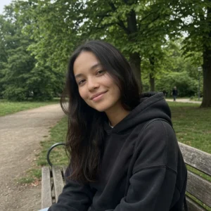 Abogado especialista en derecho administrativo: retrato de una mujer joven sonriendo en un parque verde, representando a alguien que resolvió un trámite administrativo con tranquilidad.